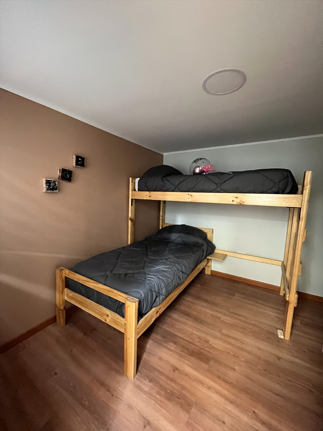 Habitación con dos camas de madera, una en altura